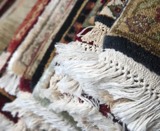 Textured colorful rugs with fringes close-up.